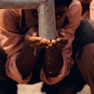 A school child drinking water from the tap