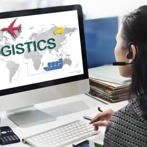 Woman infront of a computer working on a logistics freight management concept