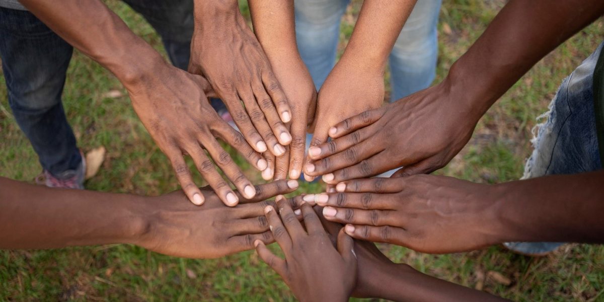 people putting hands together in the sense of community